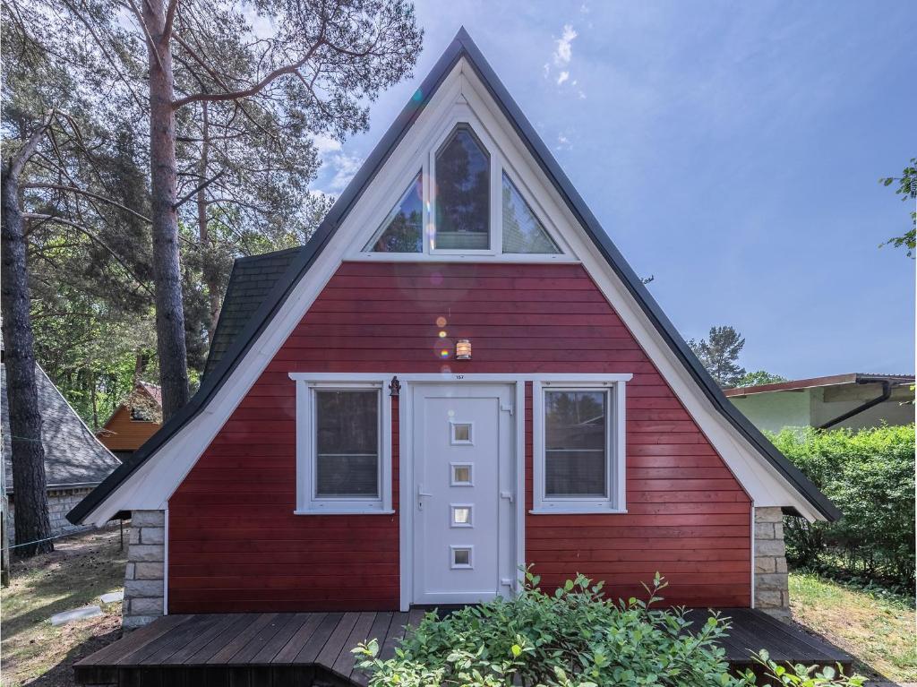 ein rotes Haus mit einer weißen Tür und Fenstern in der Unterkunft Ferienhaus Finn im Heidpark Silz in Silz