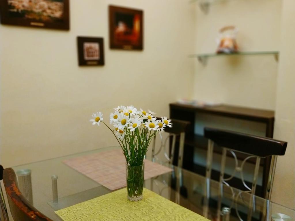 un vase de fleurs assis sur une table dans l'établissement Lviv City Apartment, à Lviv