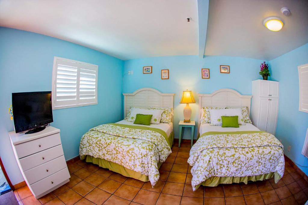 2 camas en una habitación con paredes azules en Leucadia Beach Inn en Encinitas