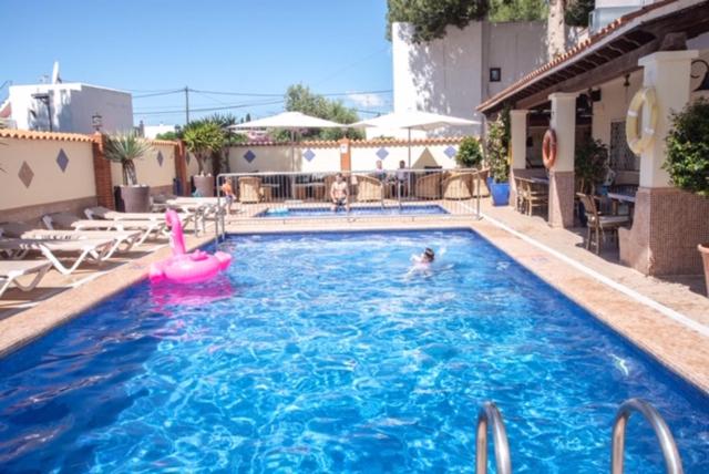 een groot zwembad met een roze opblaasbare bij El Cortijo Escana in Es Cana