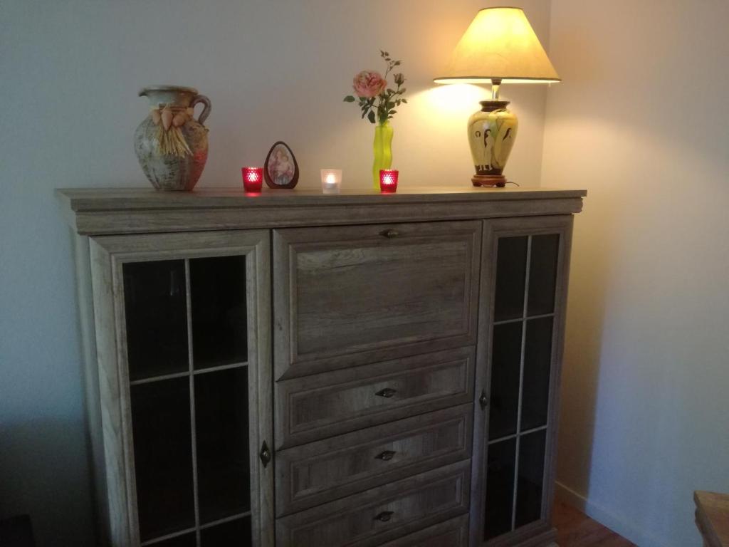 a dresser with a lamp and candles on top of it at Comfort and convenience in Rīga