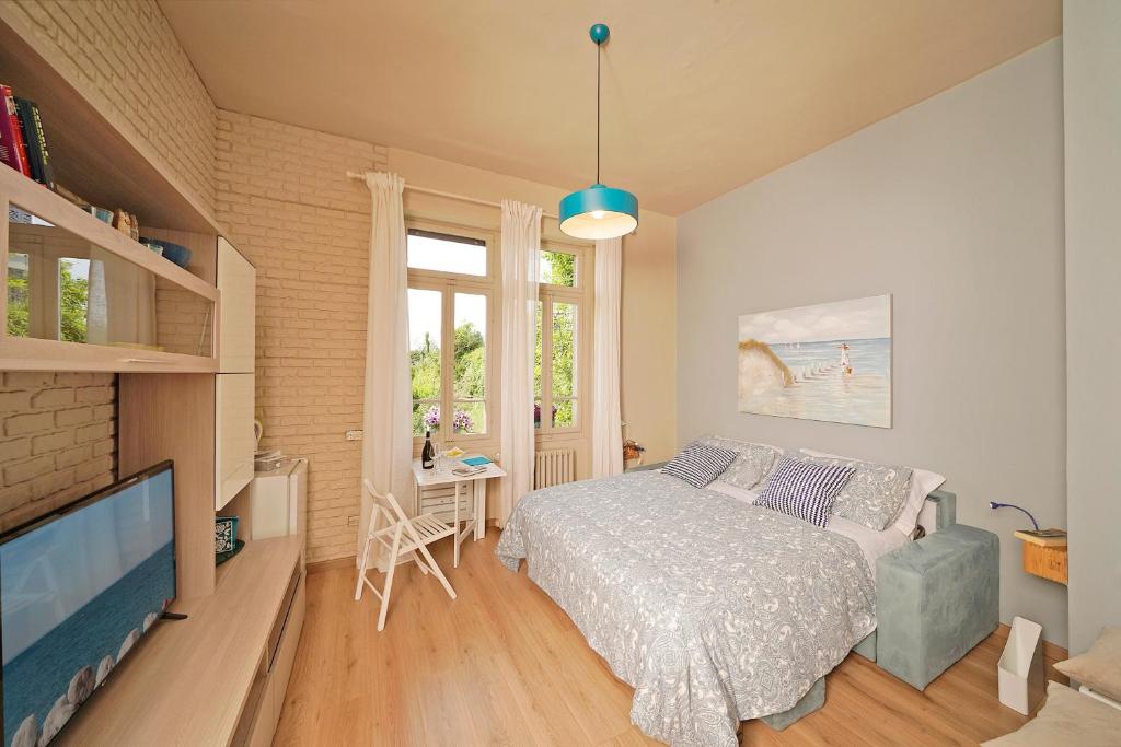 a bedroom with a bed and a flat screen tv at VALLE FIORITA 42 - Lake view Studio in Gardone Riviera
