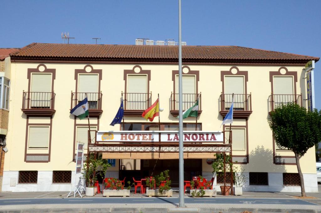 un bâtiment avec drapeaux devant lui dans l'établissement Hotel La Noria, à Lepe