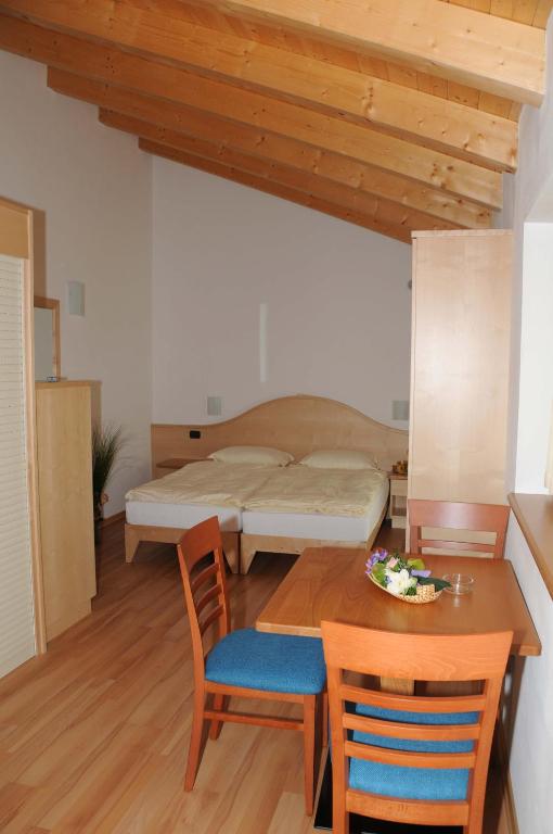 sypialnia z łóżkiem, stołem i krzesłami w obiekcie Agritur alla Veduta w Trydencie