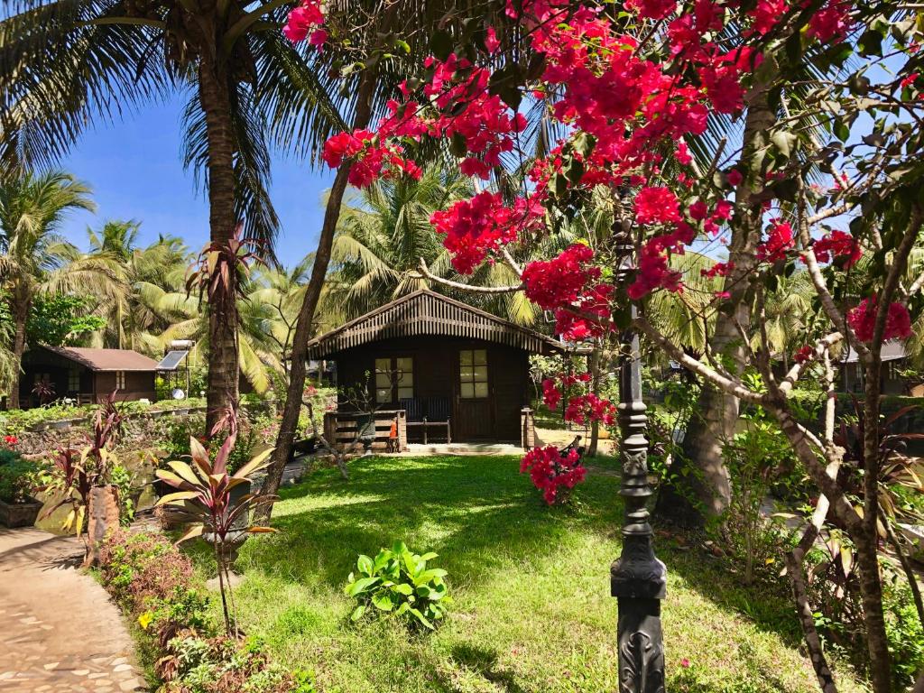 um resort com flores rosas nas árvores em Resort Primo Bom Terra Verde em Baga