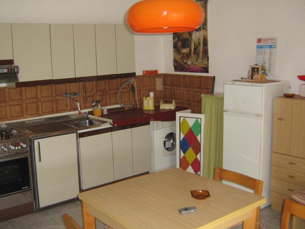 a kitchen with a table and a sink and a refrigerator at casa comoda a due passi dal mare in Il Monte