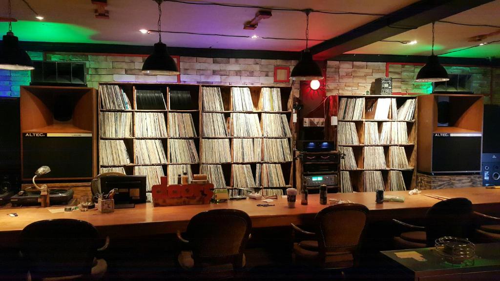 um quarto com uma mesa e cadeiras e uma grande parede de discos em Gangneung Guesthouse Myu em Gangneung