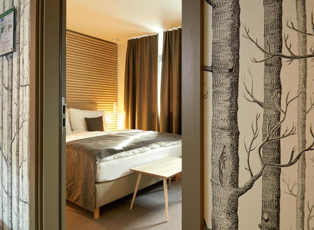 a bedroom with a bed and a tree mural at Hostellerie Stafelter in Walferdange