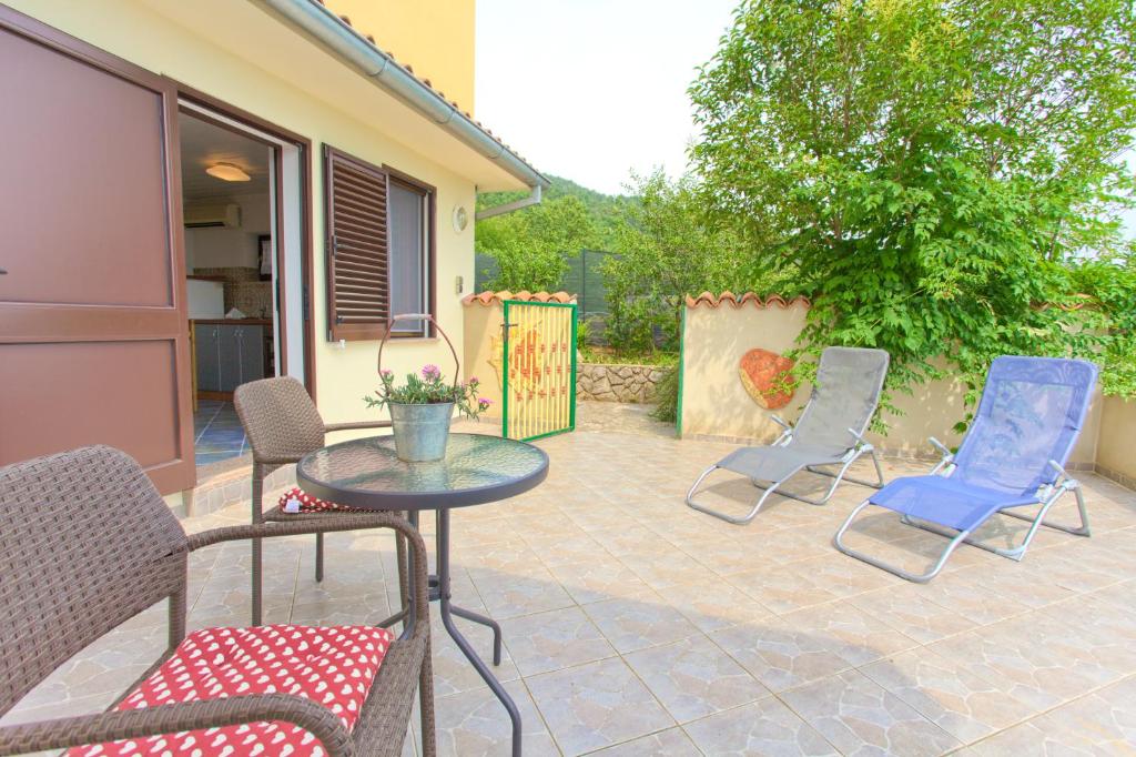 a patio with chairs and a table and a fence at Apartments Rita in Lovran