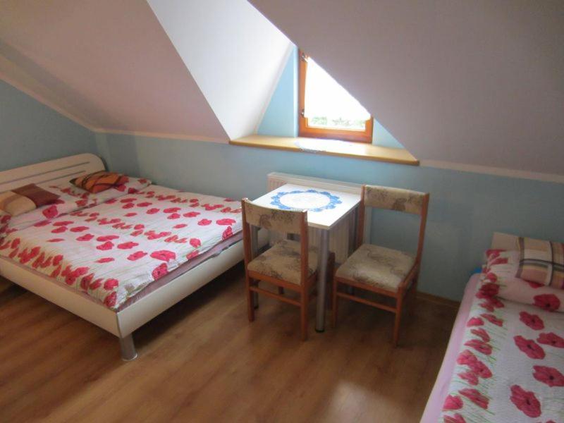 a bedroom with a bed and a table and two chairs at Ostoja w Lipowcu in Jaśliska