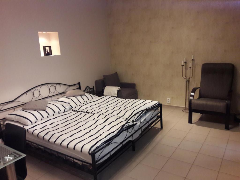 1 dormitorio con 1 cama grande y 2 sillas en Lucas Apartment - Self check-in, en Bratislava