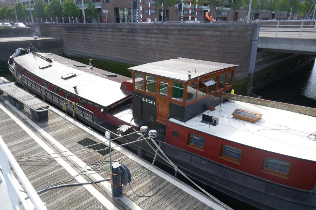 a small boat is docked in a canal at Boathotel Rotterdam Anna in Rotterdam