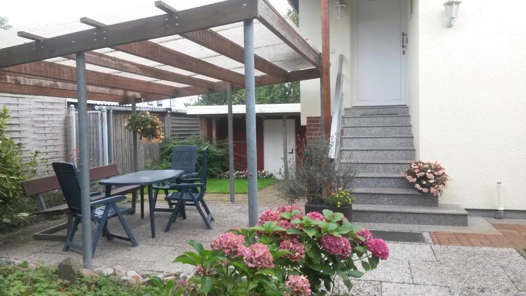 a patio with a table and chairs and flowers at Ewald von Holten in Bremerhaven