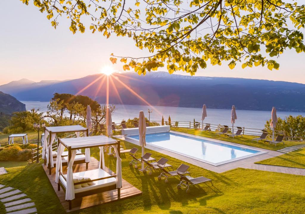 a villa with a pool and a view of the ocean at Boutique Hotel Villa Sostaga in Gargnano