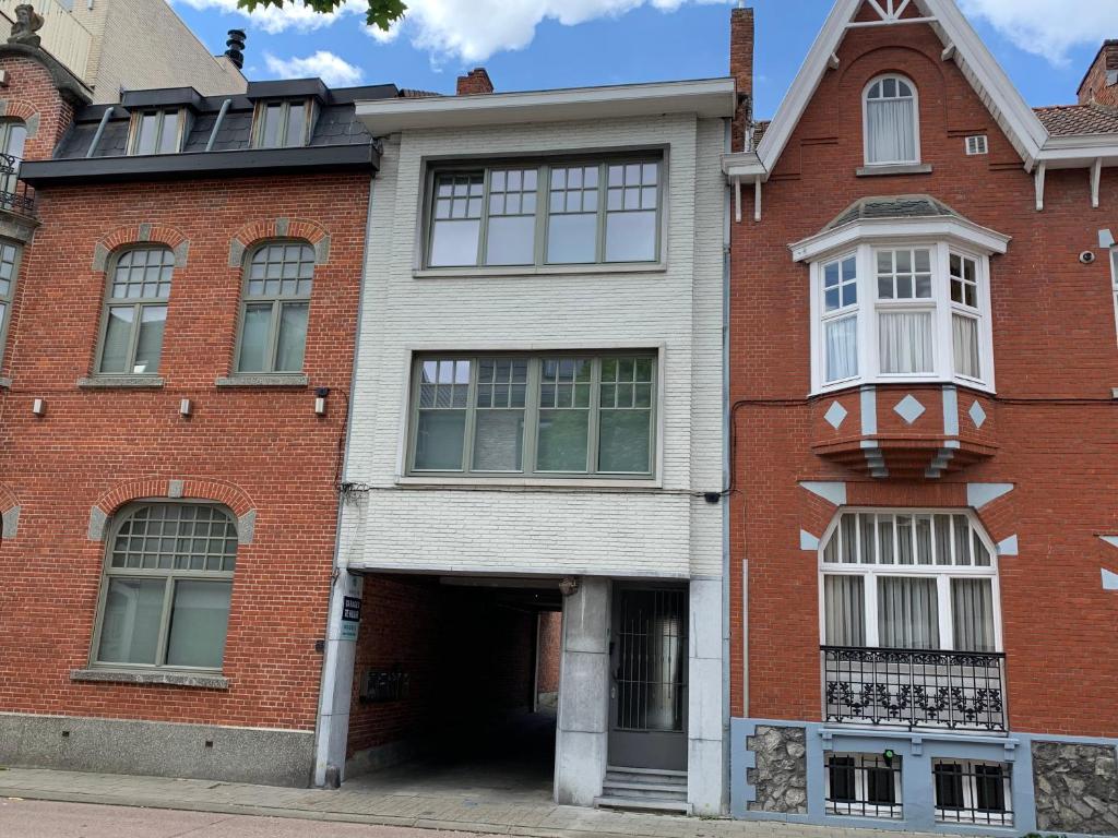 een gebouw van rode baksteen met een garage bij Hollandia City House in Hasselt