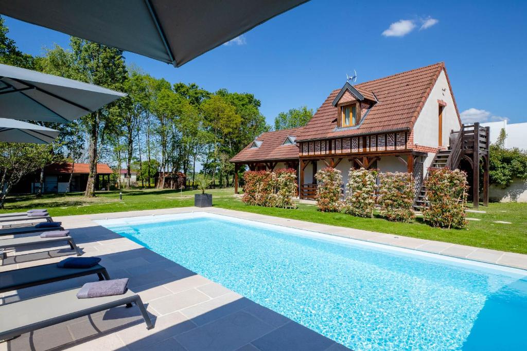 uma casa com piscina em frente a uma casa em B&B L'Orée du Bois Bourgogne - Adults Only em Saint-Nicolas-lès-Cîteaux