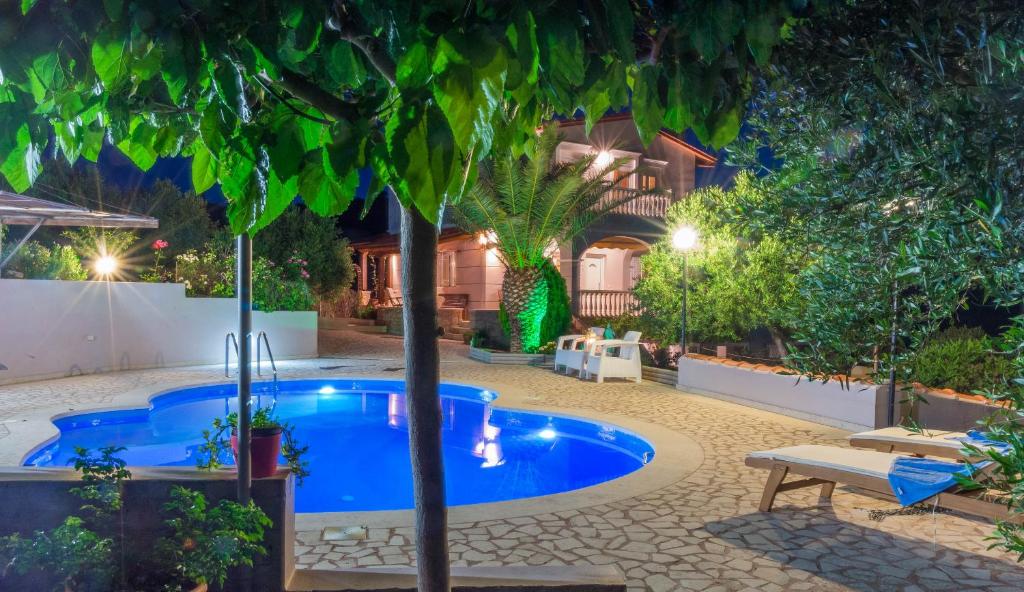 a swimming pool with a tree in a yard at Villa Palma in Sitia