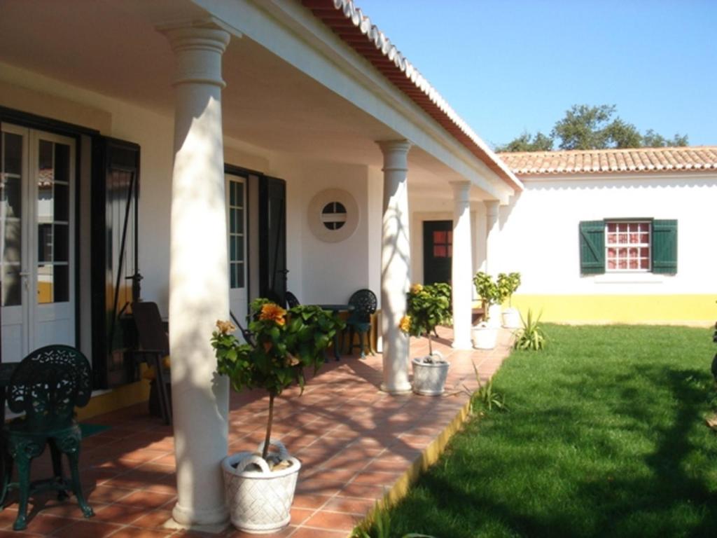 a front porch of a house with chairs and plants at Monte dos Duques in Santo Estêvão