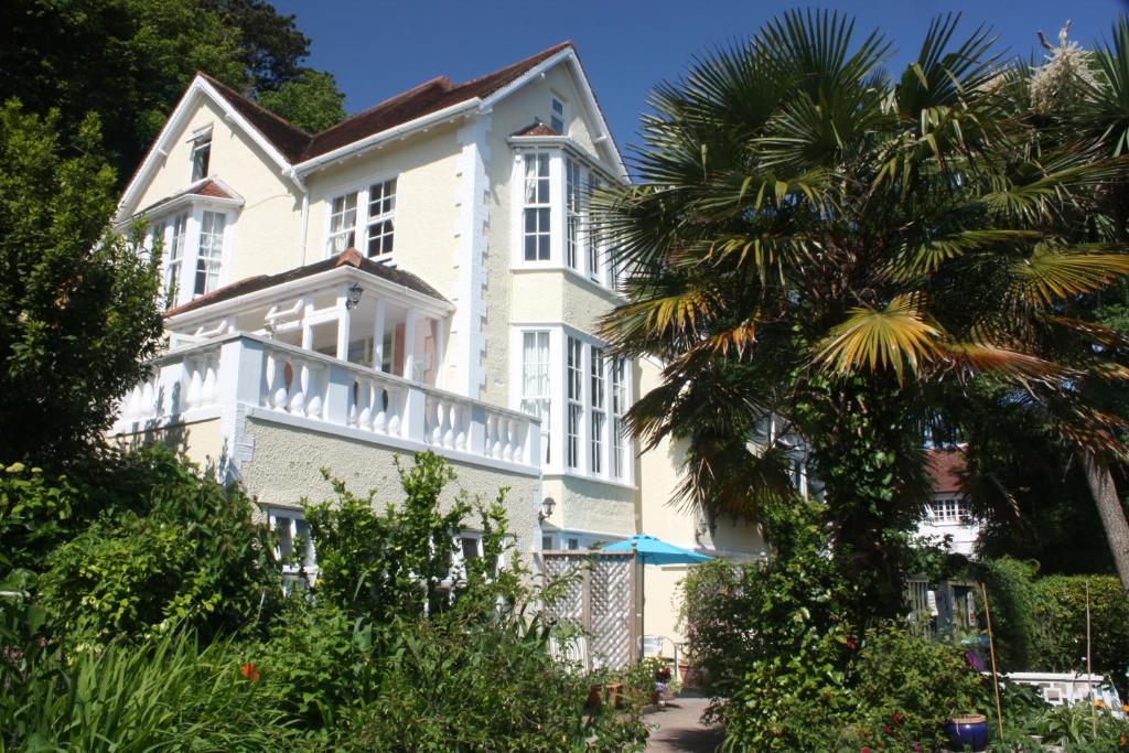 a large white building with a palm tree in front of it at The Charterhouse in Torquay