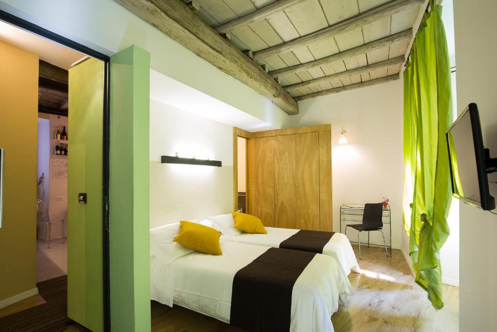 a bedroom with a large white bed with yellow pillows at Nerva Accommodation in Rome