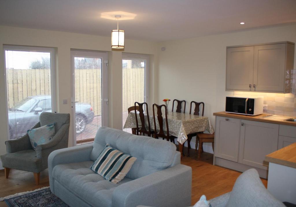 sala de estar con sofá azul y cocina en Callie's Cottage, en North Berwick