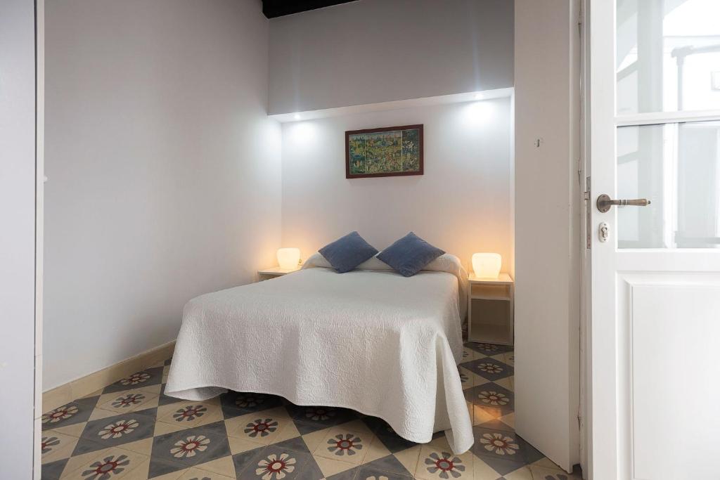 - une chambre avec un lit blanc et des oreillers bleus dans l'établissement Casa Convento, à Vejer de la Frontera