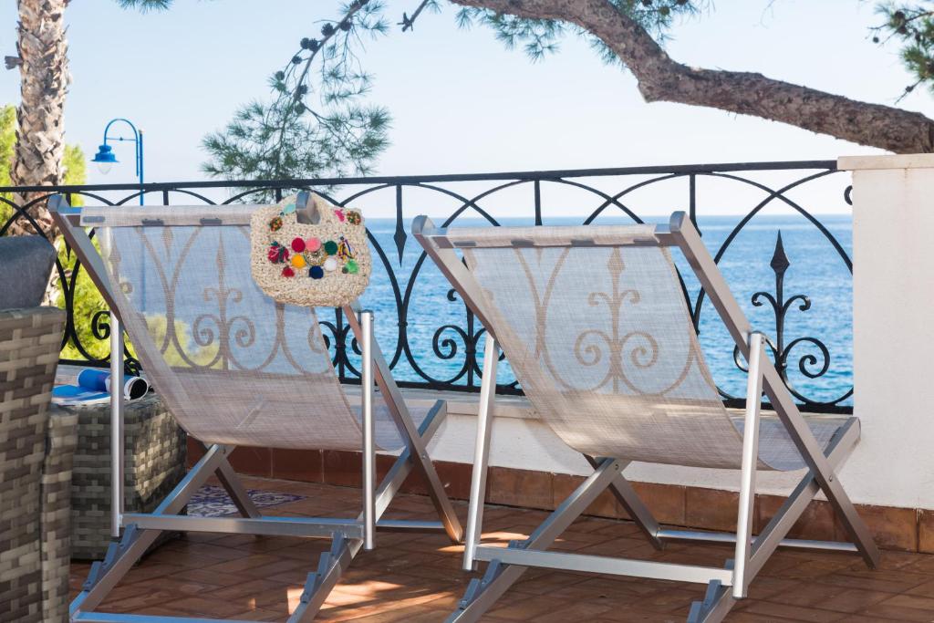 a pair of chairs on a patio with a fence at Villa Mallandrino in Mondello