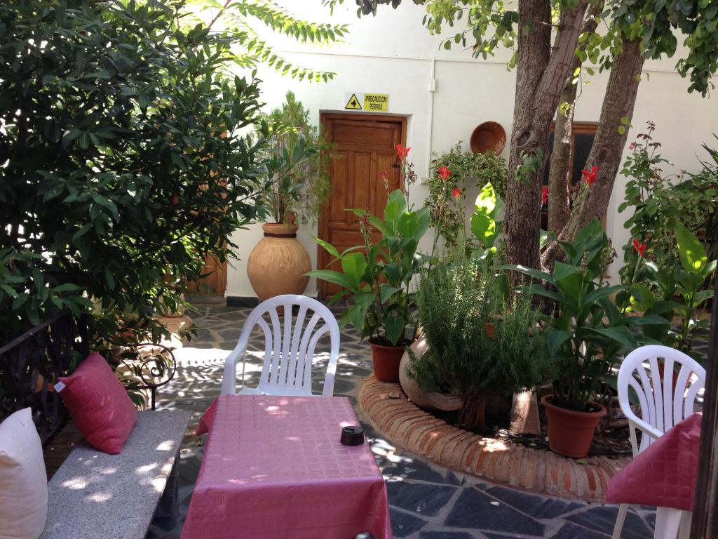 eine Terrasse mit einem rosa Tisch, Stühlen und Pflanzen in der Unterkunft Casa Rural El Rincon del Infante in Villa de Don Fadrique