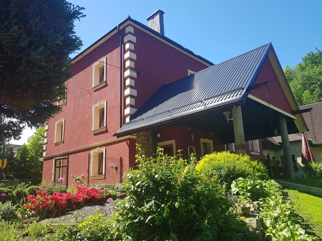 une maison rouge avec un toit noir dans l'établissement Miodowy Raj, à Targanice