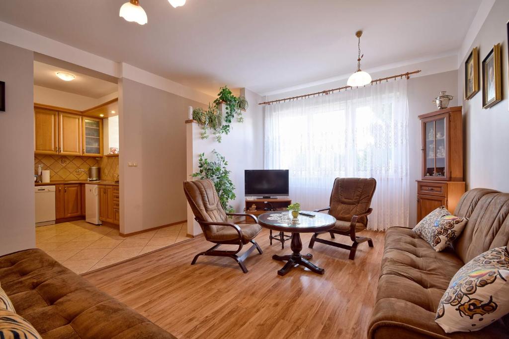 salon z kanapą i stołem w obiekcie Apartament Zuzia w Dźwirzynie