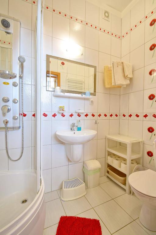 łazienka z prysznicem, umywalką i toaletą w obiekcie Apartament Zuzia w Dźwirzynie
