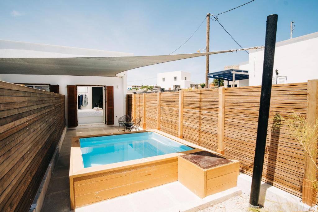 una piscina en una terraza con una valla de madera en Mesanto Luxury Suites en Megalochori