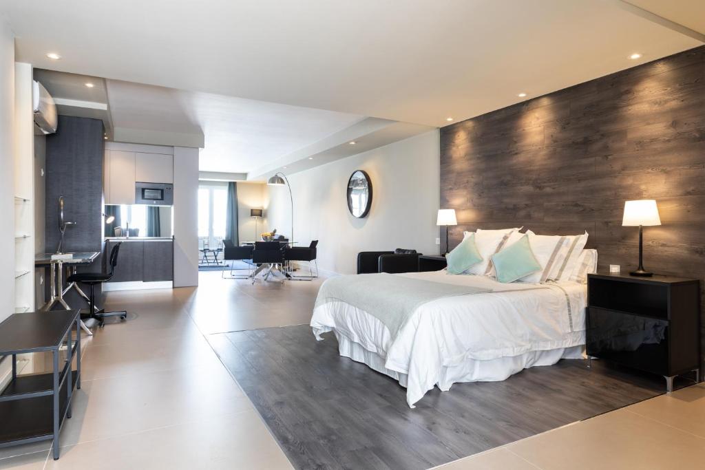 - une chambre avec un grand lit et un mur en bois dans l'établissement Rooms & Suites Loft 2E Deluxe Edition Arrecife, à Arrecife