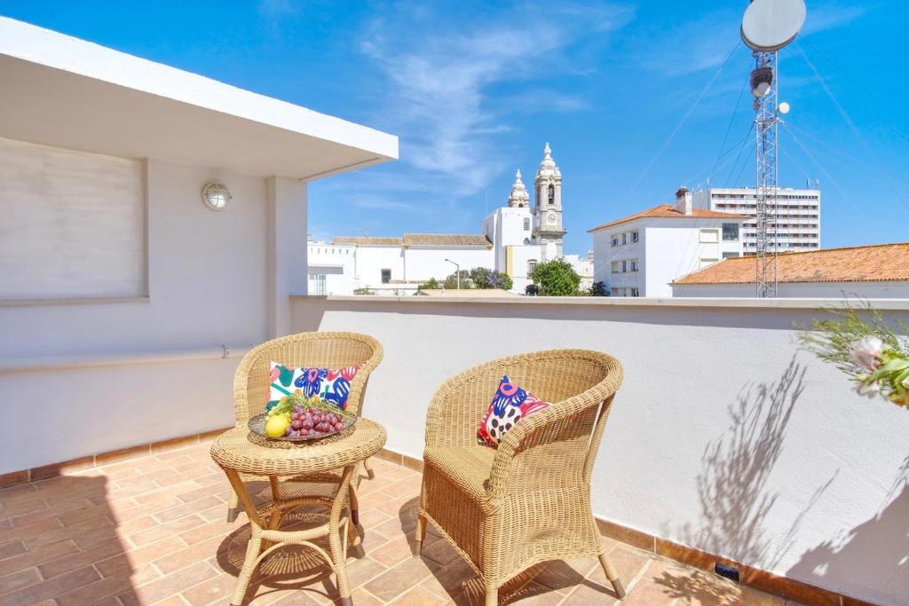 2 sillas en un balcón con vistas a la ciudad en Casa da Avó, en Faro