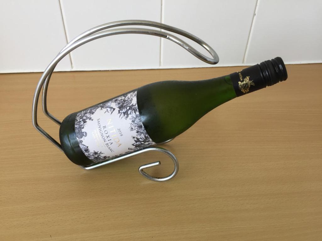a bottle of wine is hanging on a table at Ocean View B1001 in Bloubergstrand