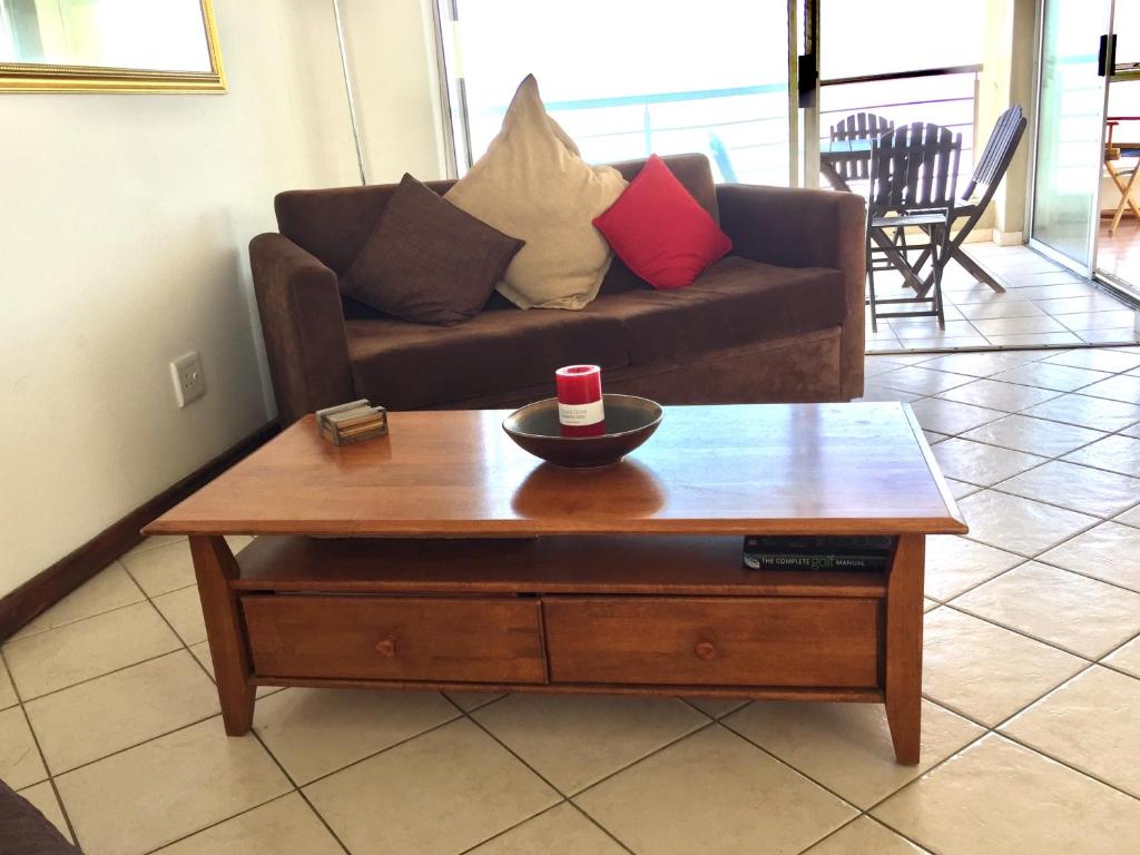 a living room with a couch and a coffee table at Ocean View B1001 in Bloubergstrand