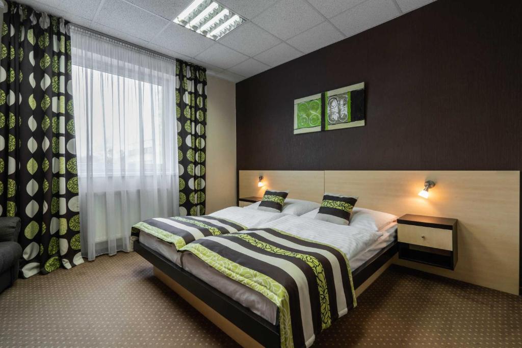 a hotel room with two beds and a large window at BNC Hotel - Restaurant - Bowling in Bratislava