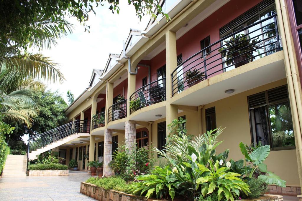 un edificio con balcones y plantas en un patio en Biyem Hotel, en Kampala