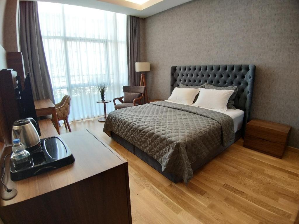 a bedroom with a bed and a desk with a television at Teknosports Otel in Istanbul