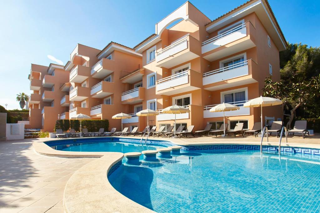 una piscina frente a un edificio en Universal Apartamentos Laguna Garden, en Canyamel