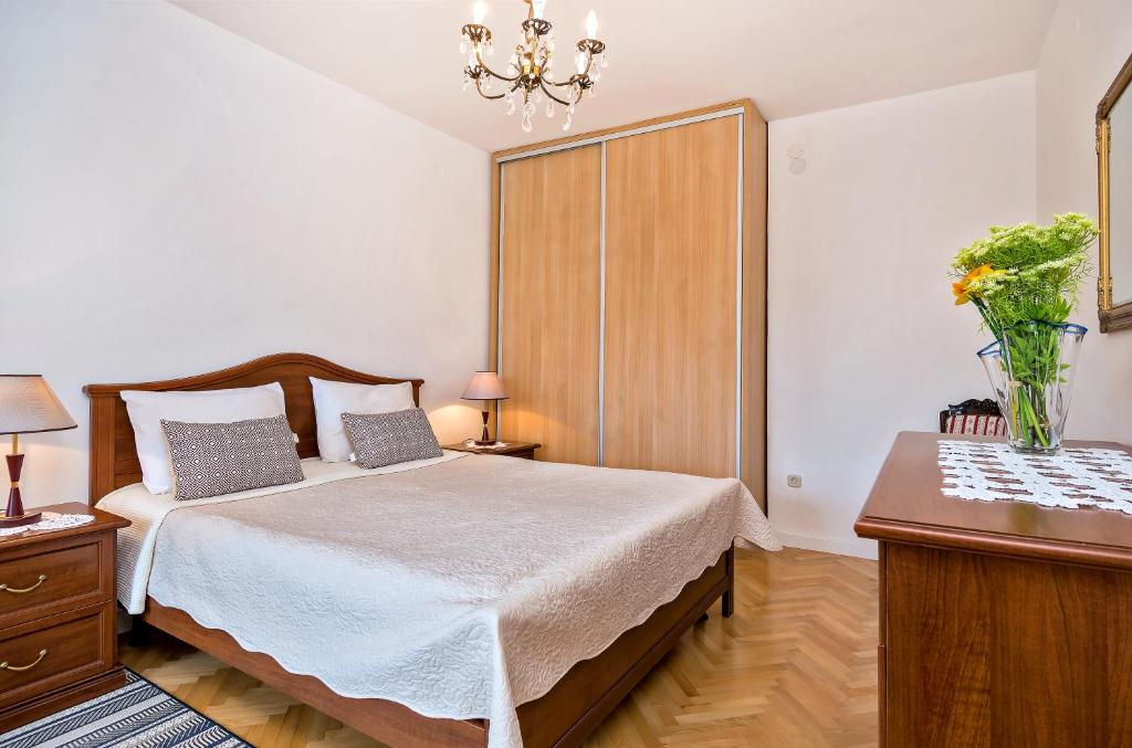 a bedroom with a bed and a vase of flowers at Apartments Emi in Split
