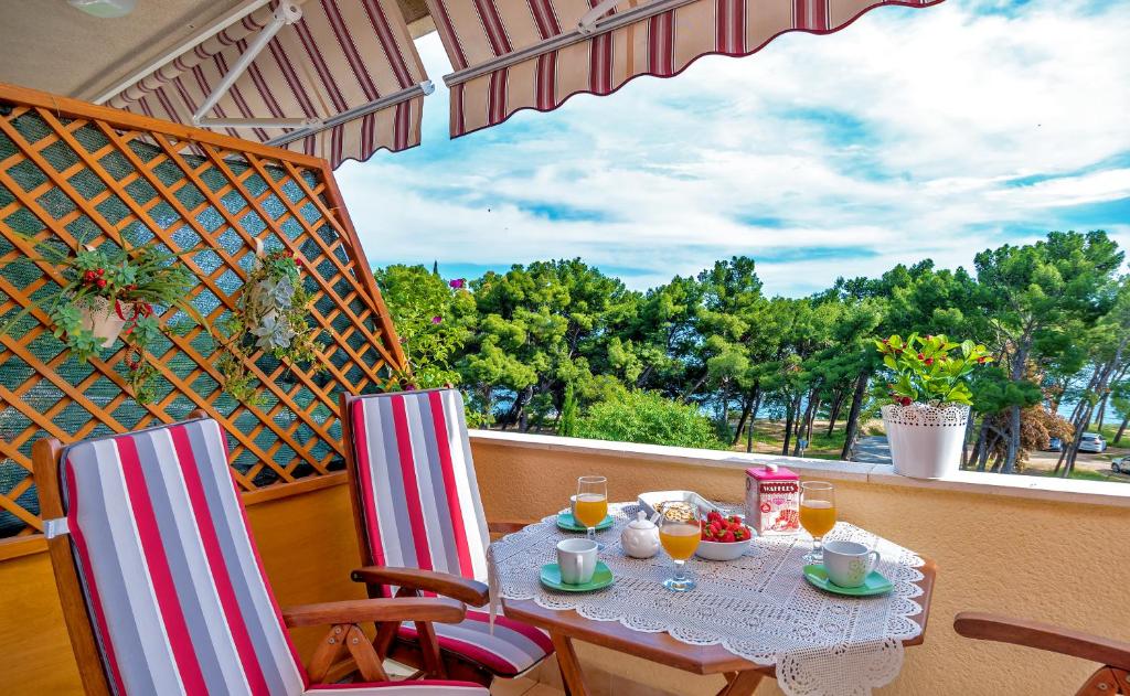 a table and chairs on a balcony with a view at Apartments Emi in Split