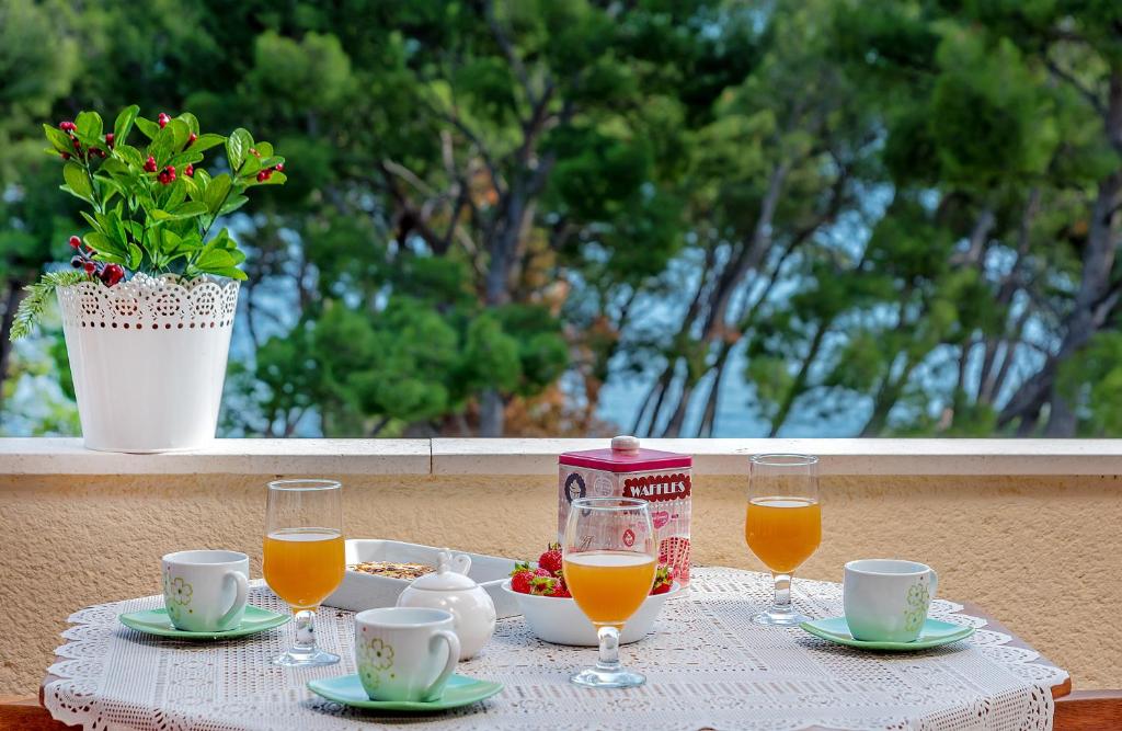 a table with a tray of food and glasses of orange juice at Apartments Emi in Split