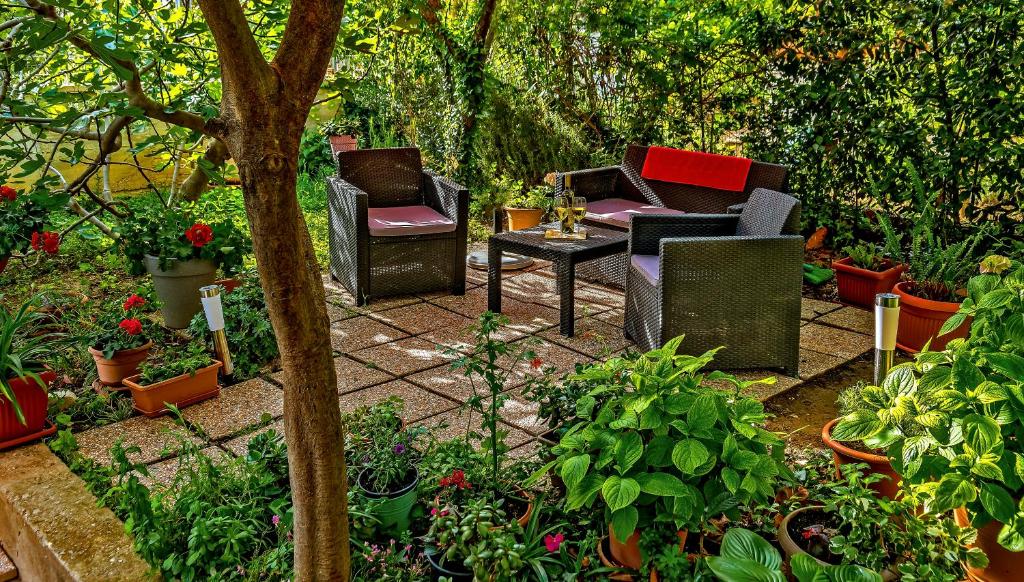 a garden with chairs and a table and plants at Apartments Emi in Split