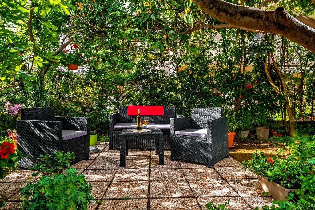 a group of chairs and a table under a tree at Apartments Emi in Split