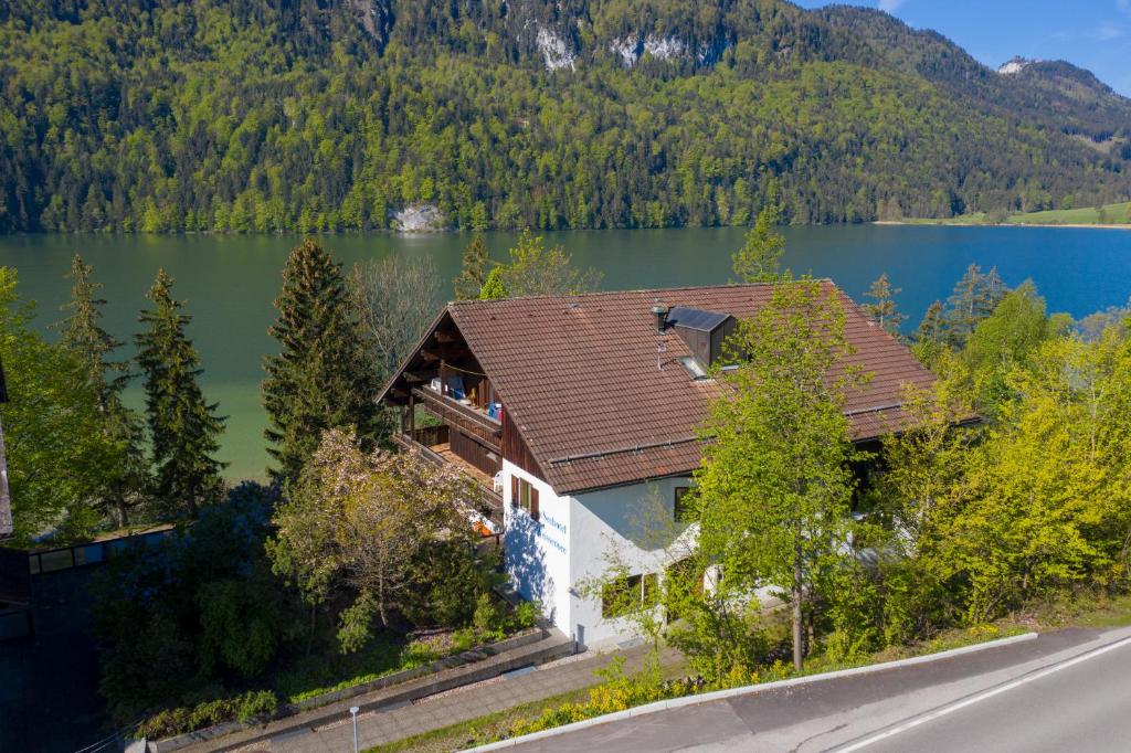 an aerial view of a house with a lake at Seehotel Weissensee in Füssen