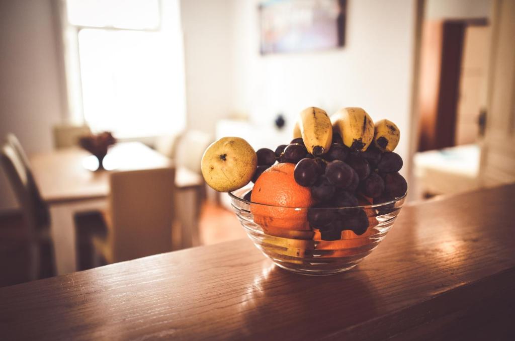 a glass bowl of fruit on a wooden table at Apartments Bazilika in Novalja