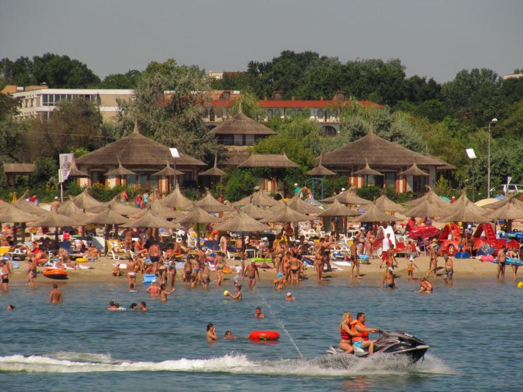 a crowd of people on a beach with umbrellas at Complex Amazon in Neptun