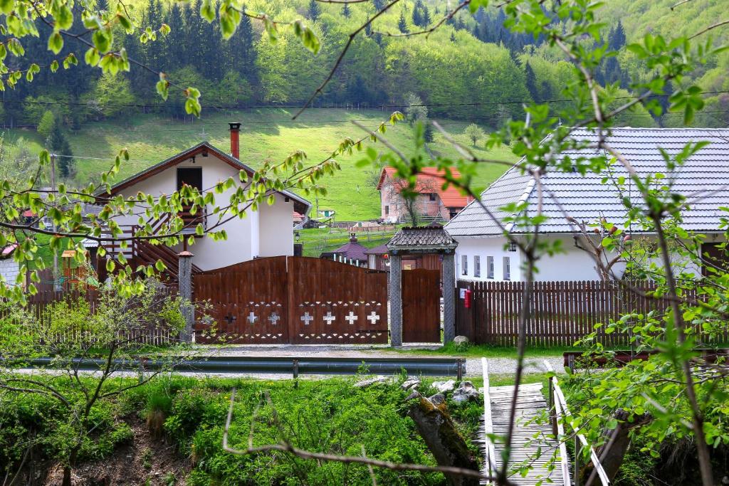 a house with a wooden fence in a yard at Gospodaria Lui Nea Ion in Vama Buzăului