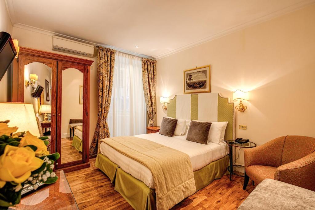 a bedroom with a large bed and a large window at Hotel Cortina in Rome